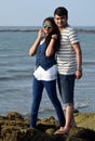 Asian young couple standing at the coral of a blue ocean. Romance at sea beach for newly married couple Royalty Free Stock Photo