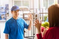 Delivery man making grocery service giving fresh vegetables in paper bag to woman customer Royalty Free Stock Photo