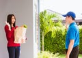 Delivery man making grocery service giving fresh vegetables in paper bag to woman customer