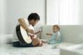 Happy Asian Young Father and Adorable little boy son sitting on bed playing acoustic guitar together at home Royalty Free Stock Photo