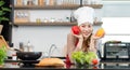 Asian young female chef wears white tall cook hat and apron smiling posing holding red yellow sweet peppers ready to cooking food Royalty Free Stock Photo