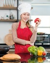 Asian young female chef wears white tall cook hat and apron smiling posing holding red yellow sweet peppers ready to cooking food Royalty Free Stock Photo