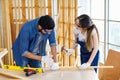 Asian young female engineer architect foreman labor worker wears safety goggles gloves and apron holdind using steel hammer Royalty Free Stock Photo