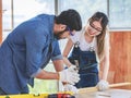 Asian young female engineer architect foreman labor worker wears safety goggles gloves and apron holdind using steel hammer Royalty Free Stock Photo