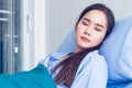 Asian young female patients wearing blue shirts lying in the bed with a bright face Have better symptoms while waiting for the
