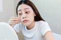 Asian young female stress looking mirror check have dark eye circles on face from staying up sleepy late. from hard work, no time