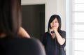 Asian woman using hair irons with straightening in room Royalty Free Stock Photo