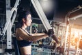 Asian young fitness woman execute exercise with exercise-machine in gym