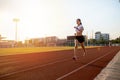 Asian Young fitness woman runner running on stadium track -healthy lifestyle and sport concepts