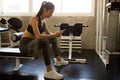 asian young fitness woman in sportswear with towel using mobile smart phone and listening music with earphones relaxing sitting Royalty Free Stock Photo