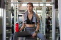 asian young fitness woman with towel listening music with earphones holding water bottle relaxing sitting on Weight lifting Royalty Free Stock Photo