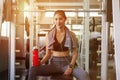 asian young fitness woman with towel listening music with earphones holding water bottle relaxing sitting on Weight lifting Royalty Free Stock Photo