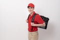 Asian Young food delivery man wearing red uniform carrying food baggage smiling on white background Royalty Free Stock Photo