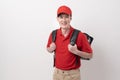 Asian Young food delivery man wearing red uniform carrying food baggage smiling on white background Royalty Free Stock Photo