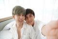 Asian young gay couple taking a selfie smile and looking at camera