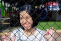 Asian young girl behind chain link fence Royalty Free Stock Photo