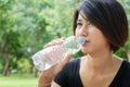 Asian young girl drink water in green park Royalty Free Stock Photo