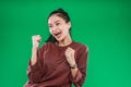 Asian young girl expressing face happiness with clenched into fists and raised two hands