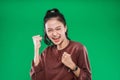 Asian young girl expressing face happiness with clenched into fists and raised two hands