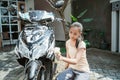 Asian young girl washing his motorcycle scooter with soap and sponge Royalty Free Stock Photo