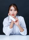 Asian young glamour trendy fashionable female model wearing makeup in casual white shirt sitting smiling holding face cream bottle