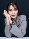 Asian young glamour trendy urban fashionable female model wearing makeup in casual fashion shirt wrist watch earring sitting smil Royalty Free Stock Photo