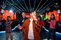 Asian young guy with friends dancing and singing at karaoke bar Royalty Free Stock Photo