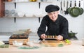 Asian young handsome chef man, in black uniform, smiling and holding on japanese food called takoyaki in plate ready to serve Royalty Free Stock Photo