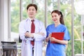 Asian young handsome professional successful male doctor in white lab coat standing smiling crossed arms holding stethoscope with Royalty Free Stock Photo