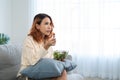 Asian young happy attractive woman eat green salad while watch movie. Beautiful girl feel joyful and enjoy eating vegetables Royalty Free Stock Photo