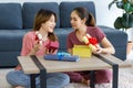 Asian young happy cheerful female teenager LGBTQ lesbian lover couple sitting smiling together on carpet floor in living room Royalty Free Stock Photo