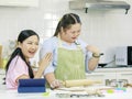 Asian young happy chubby down syndrome autistic daughter wears apron standing smiling laughing in kitchen touching hands with Royalty Free Stock Photo