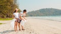 Asian young happy family activists collecting plastic waste on beach. Asia volunteers help to keep nature clean up and pick up Royalty Free Stock Photo