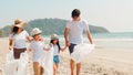 Asian young happy family activists collecting plastic waste and walking on beach. Asia volunteers help to keep nature clean up Royalty Free Stock Photo