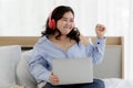 Asian young happy funny fat chubby oversized woman wears big red headphones around head listening to music and sit enjoy alone