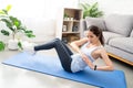 Asian young healthy woman exercising on yoga mat at home, she is doing a Russian twist Royalty Free Stock Photo