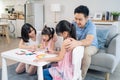 Asian young kid daughter coloring and painting on paper with parents. Happy family activity, Little girl children learn how to Royalty Free Stock Photo