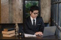 Asian young lawyer working with laptop and hammer with scales giving online legal