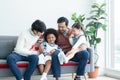 Asian young LGBTQ gay couple playing ukulele and singing with little Caucasian and African adopted kid together at home Royalty Free Stock Photo