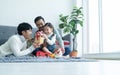Asian young LGBTQ gay family giving gift to little adopted daughter on birthday or special day in living room at home