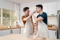 Asian young LGBTQ male gay family enjoy bake bakery in kitchen at home. Attractive handsome romantic man couple wear apron feeling