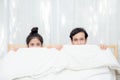 Asian young lovely couple sitting in a bed, happy smile looking at camera. Royalty Free Stock Photo