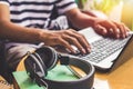 Asian Young man in black and white shirt sitting at cafe using laptop computer .Learning internet, Education technology concept Royalty Free Stock Photo