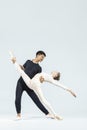 Dance Couple of Asian Young Man and Caucasian Woman Performing As Ballet Dancers Over Grey in Studio During Suppots As Classical Royalty Free Stock Photo