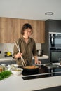 Asian young man cooking chinese or taiwanese tomato scrambled eggs at kitchen. Royalty Free Stock Photo