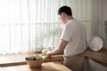 Asian young man cooking , preparing breakfast with healthy food in kitchen at home , healthy lifestyle Royalty Free Stock Photo