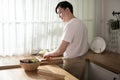 Asian young man cooking , preparing breakfast with healthy food in kitchen at home , healthy lifestyle Royalty Free Stock Photo