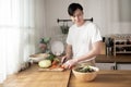 Asian young man cooking , preparing breakfast with healthy food in kitchen at home , healthy lifestyle Royalty Free Stock Photo