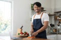 An Asian young man cooking , preparing breakfast with healthy food in kitchen at home , healthy lifestyle Royalty Free Stock Photo