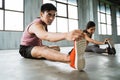 Asian young man doing legs stretching before core exercise Royalty Free Stock Photo